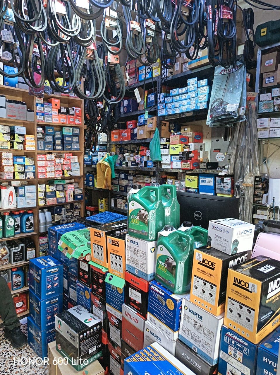Fully stocked workshop shelves with batteries, engine oil and spare parts