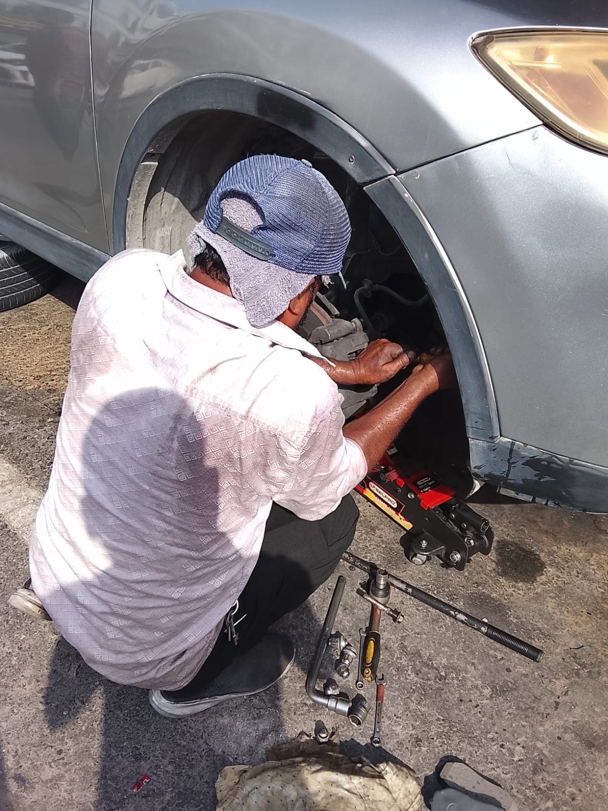 Technician kneeling to carry out a wheel and brake repair