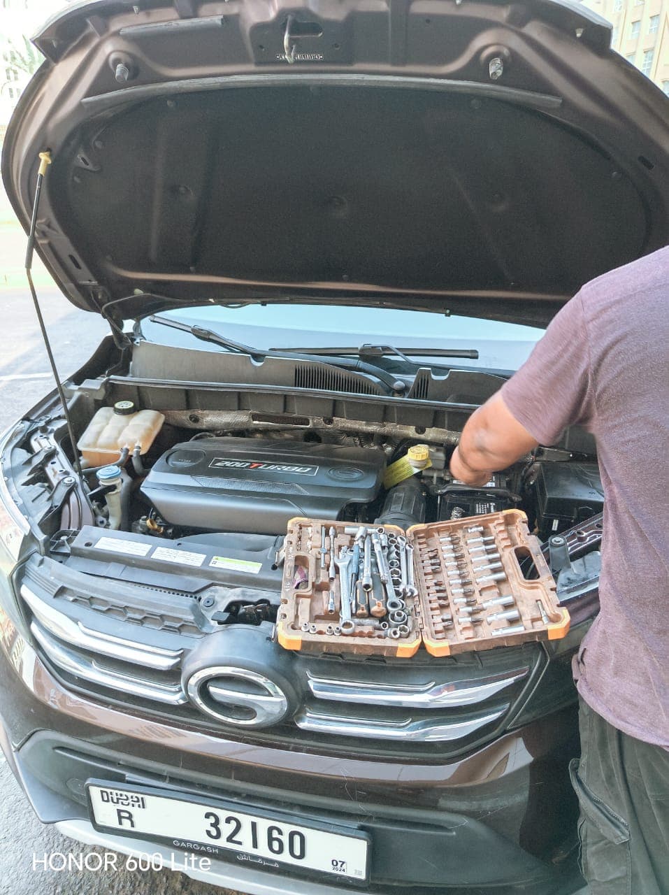 Mobile technician servicing an engine bay with a full tool tray