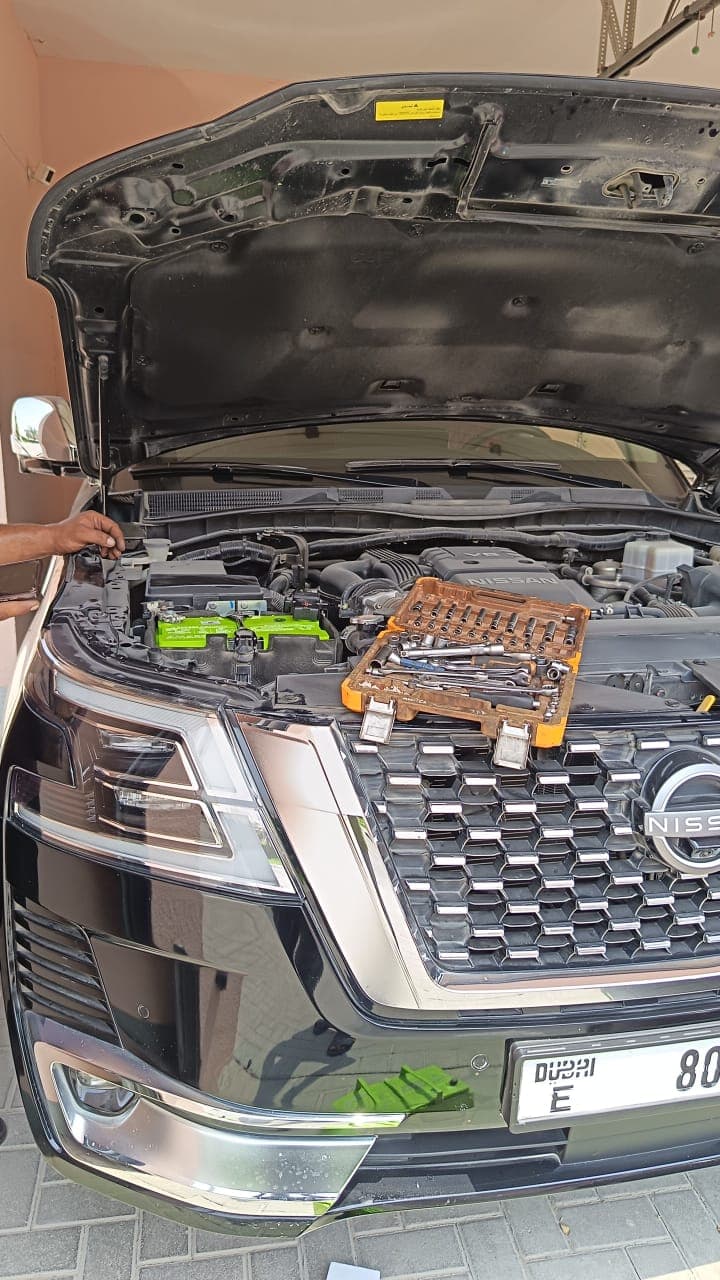 Mobile battery replacement in progress on an SUV engine bay