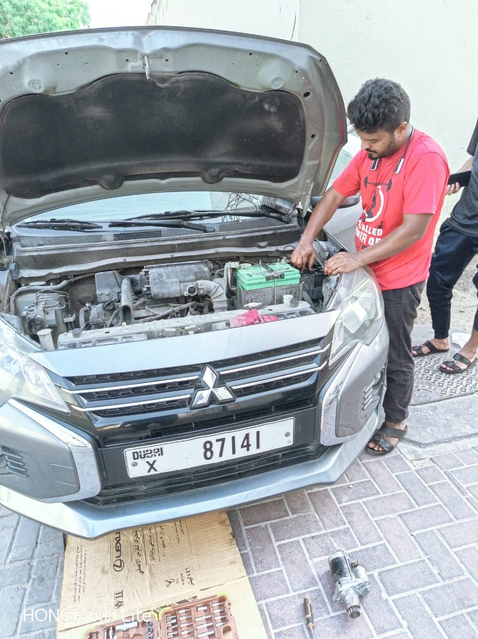 Technician replacing a car battery roadside